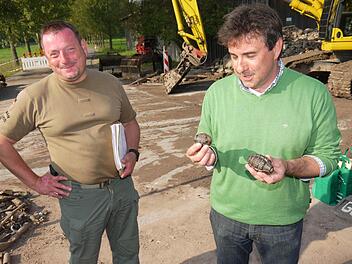In der rechten Hand hält Bürgermeister Rolf Rosenbauer eine deutsche Handgranate, in der linke eine amerikanische. Heinrich Bernhard Scho ist froh, dass er in Untersiemau endlich Fertig ist.