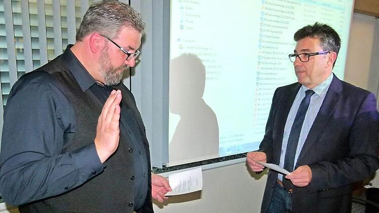 Bürgermeister Rolf Rosenbauer (rechts) vereidigte den neuen Gemeinderat Markus Geiger (links), der für den aus beruflichen Gründen ausgeschiedenen und mit lobenden Worten verabschiedeten Markus Geiger (SPD/FB) in das Gremium nachrückte. Foto: Lothar Weidner