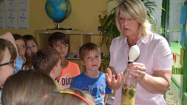 Fachberaterin Brigitte Krieglstein erklärt den Jungen und Mädchen der Klasse 3 b die Funktionsweise einer Biogasanlage. Dafür hat sie eine solche in einer Plastikflasche nachgebaut. Foto: Kathrin Kupka-Hahn