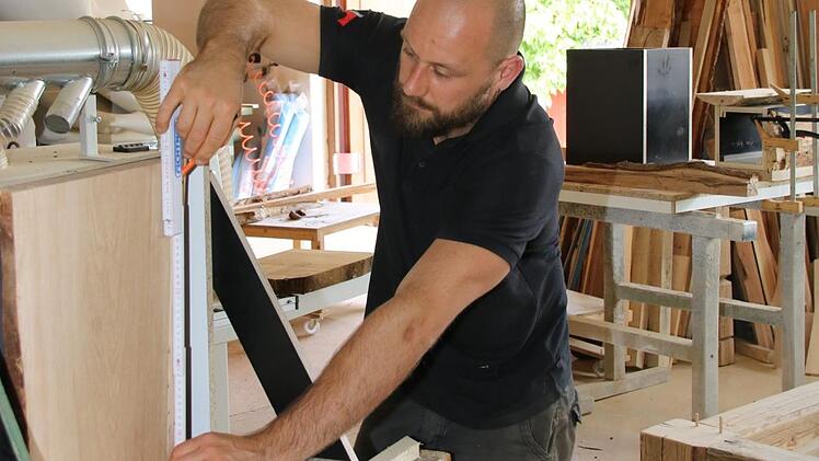 Mit seinen Möbeln aus Holz und Beton hat Denny Friedrich  sogar Kölner Sterne-Gastronomen überzeugt. An dem Verfahren, die beiden Werkstoffe perfekt miteinander zu verbinden, hat er über Jahre getüftelt. Foto: Jürgen Gärtner