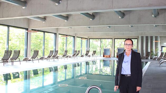 Fürs Foto hat Ute Trabert, Hotelmanagerin des Cup Vitalis, die Maske abgenommen. Das ist möglich, da sie alleine vor dem 20-Meter Sportbecken steht, das von den Gästen unter strengen Hygienevorgaben genutzt werden darf.  Foto: Charlotte Wittnebel-Schmitz