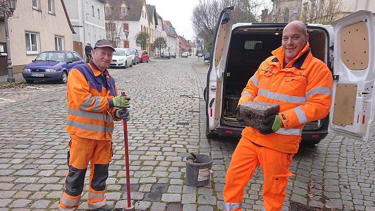 Willi (links) und Michael vom Höchstadter Bauhof füllen die Löcher der herausgearbeiteten Steine mit Kaltasphalt.   Foto: Andreas Dorsch