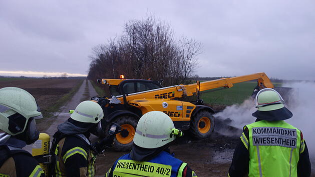 Der gro&szlig;e brennende Haufen wurde mit einem Teleskopbaggerlader ge&ouml;ffnet und brachte eine unliebsame Entdeckung zu Tage.