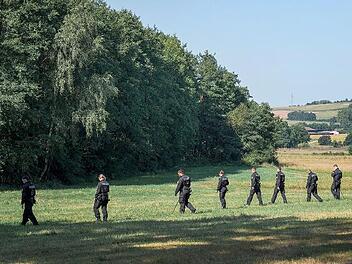 Polizisten und Polizistinnen der Bereitschaftspolizei laufen im Raum Eggolsheim/Hallerndorf &uuml;ber eine Wiese auf der Suche nach der Vermissten und Gegenst&auml;nden.
