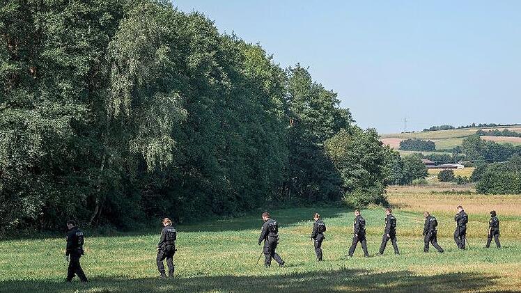 Polizisten und Polizistinnen der Bereitschaftspolizei laufen im Raum Eggolsheim/Hallerndorf &uuml;ber eine Wiese auf der Suche nach der Vermissten und Gegenst&auml;nden.