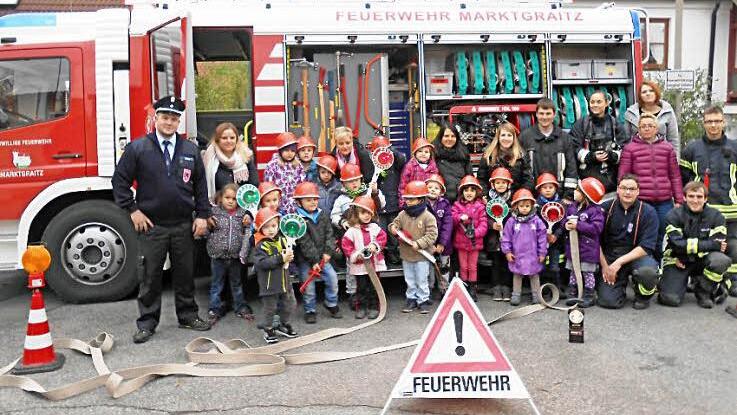 19 Vorschulkinder der Tagesstätte St. Anna in Lichtenfels erlebten unter der Leitung des Kommandanten Thomas Müller (links) einen ereignisreichen Nachmittag bei der Feuerwehr Marktgraitz. Foto: Alfred Thieret