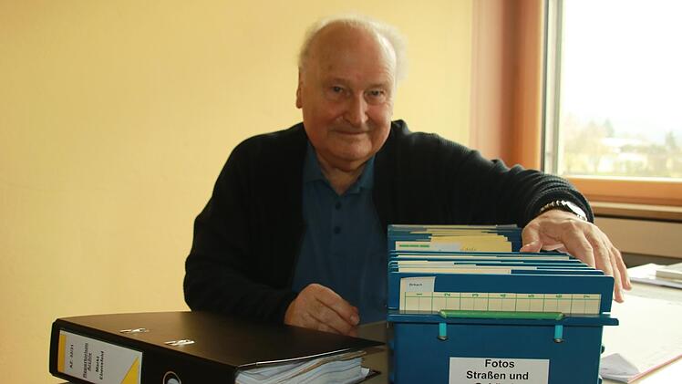 Gerhard Arneth mit dem Repertorium (dem "Findbuch") und mit einer Box voller sortierter und beschrifteter Fotos aus Ebensfeld und den Gemeindeteilen Foto: Matthias Einwag