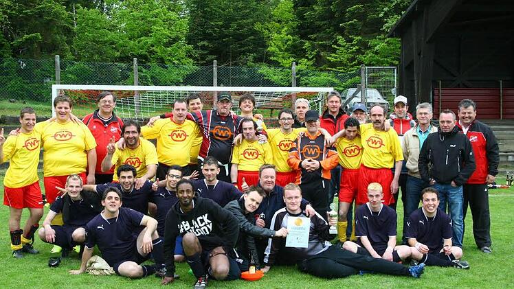 Die Finalisten aus Nürnberg (blaue Trikots) und Kaufbeuren (gelbe Trikots) stellen sich zum Erinnerungsfoto. Mit im Bild Organisator Gerhard Leinfelder (rechts) vom TSV Presseck, Ludwig Dinger vom Bayerischen Fußballverband (Dritter von rechts) sowie Holger Grebe vom Landesverband Bayerische Lebenshilfe (Fünfter von rechts).