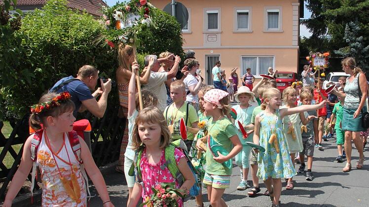 Ein bunter Zug schlängelte sich beim Wiesenfest durch Melkendorf. Viele Schaulustige machten einen Schnappschüsse. Foto: Stephan Stöckel