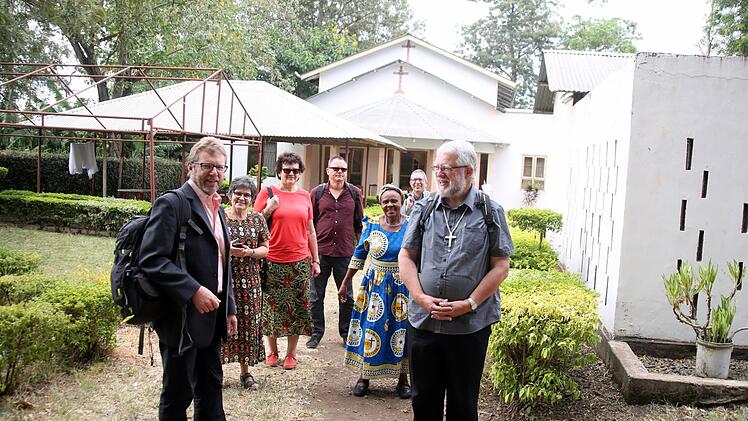 Am letzten Sonntag machten sich die Gäste von ihrem Gästehaus in Kingori (Rafiki Hostel, im Hintergrund) zu Fuß auf zum Gottesdienst in Kwakiringa. Von rechts: Pfarrer Heinz Geyer, Heiko Geuß, Emma, Thomas Kraftzyk, Waltraud Leppert, Veronika und Friedrich Flierl. Für "Mama Veronika" war es ein "Heimspiel": Sie ist Gemeindemitglied in Kwakiringa. Foto: Bettina Knauth