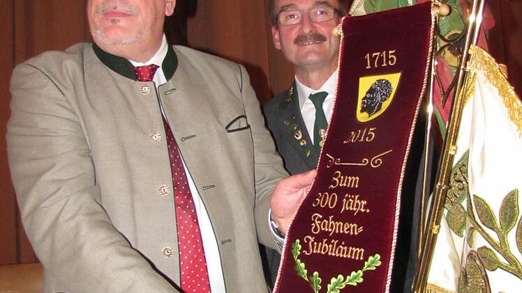 Die Traditionsfahne der Coburger Schützen ist 300 Jahre alt. Zum Jubiläum spendierte die Stadt Coburg ein neues Fahnenband, das Oberbürgermeister Norbert Tessmer bei der Königstafel gleich befestigte. Foto: Martin Koch