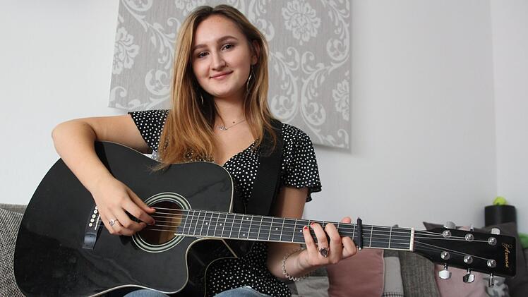 Nach der Schule greift Nisa gerne zu ihrer Gitarre.  Singen und Tanzen sind ihre große Leidenschaft. Foto: Ronald Heck