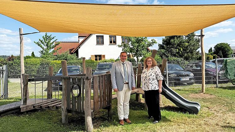 Michelaus B&uuml;rgermeister Jochen Weber mit Kindergartenleiterin Regina D&uuml;mmlein unter dem neuen Sonnensegel.