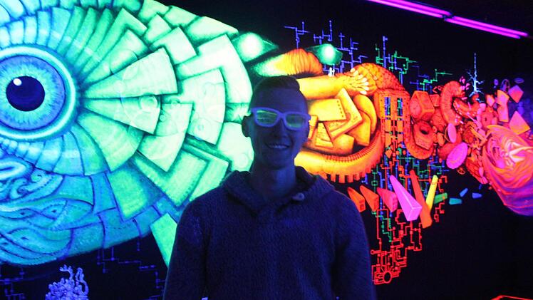 Willkommen im Schwarzlicht-Universum: Willi Keterling erklärt die Technik, die diesen Raum dreidimensional wirken lässt.