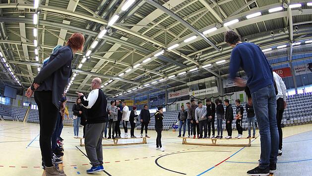 Schwierige Aufgabe f&uuml;r die Teilnehmer am "Doppelpass"-Projekt: Am Ende soll jede Gruppe nach der K&ouml;rpergr&ouml;&szlig;e auf der Bank sortiert sein - aber ohne zu reden und ohne dabei den Hallenboden zu ber&uuml;hren.  Foto: Christoph Winter
