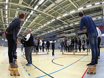 Schwierige Aufgabe für die Teilnehmer am "Doppelpass"-Projekt: Am Ende soll jede Gruppe nach der Körpergröße auf der Bank sortiert sein - aber ohne zu reden und ohne dabei den Hallenboden zu berühren.  Foto: Christoph Winter