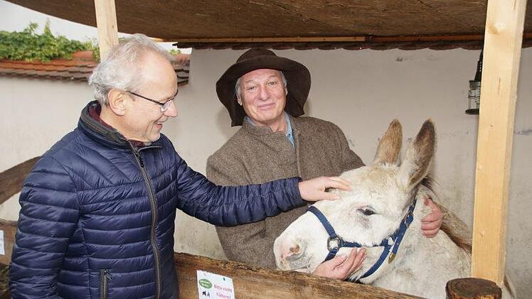 Auch Dekan Hans-Martin Lechner streichelt den Esel, assistiert von Manfred Kr&ouml;ner. Foto: Joseph Beck