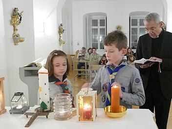 Lioba und Kilian entzünden mit dem Licht aus Bethlehem die Kerzen in der Kapelle des Bischofshauses.  Foto: Marion Krüger-Hundrup