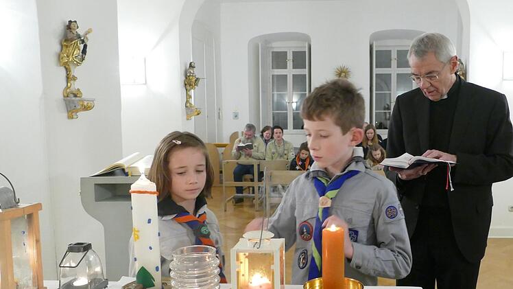 Lioba und Kilian entzünden mit dem Licht aus Bethlehem die Kerzen in der Kapelle des Bischofshauses.  Foto: Marion Krüger-Hundrup