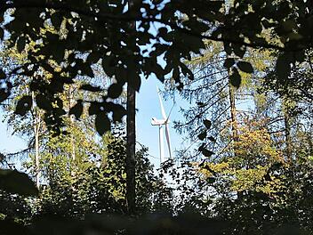 Blick zwischen Bäumen hindurch auf ein Windrad. So eine Perspektive ist vielleicht bald auch in Sulzthal zu sehen. Foto: Archiv/ Markus Reeh