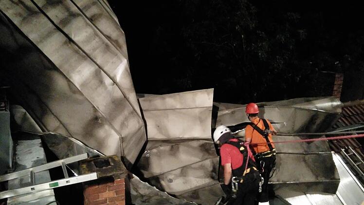 Das Blechdach verfing sich an einem Kamin. Die Feuerwehrleute mussten die Teile auseinanderflexen und abseilen. Foto: Feuerwehr Coburg