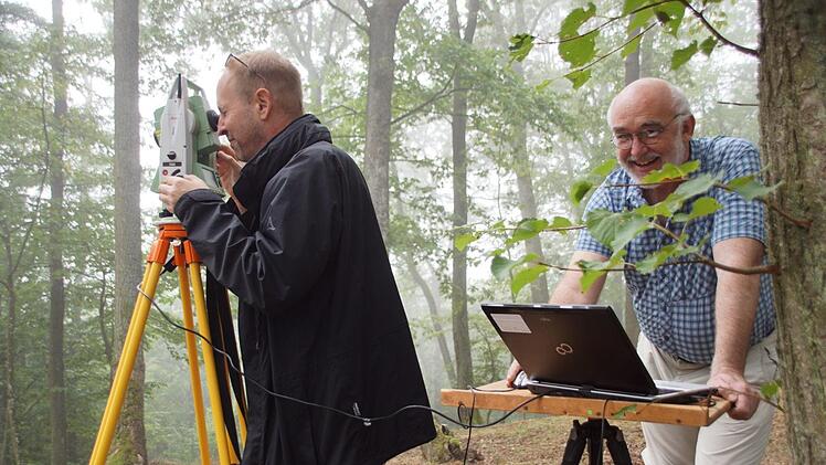 Morgens halb neun im nebligen Wald: die Stimmung ist gut bei Claus Schaffranek am Laptop und Michael Mark am Tachymeter. Beide sind ehrenamtliche Helfer bei der geoelektrischen Prospektion am Eltmanner Burgstall. Foto: Christiane Reuther