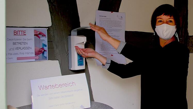 Wer in Seßlach die Einrichtung der Flender'schen Spitalstiftung aufsuchen darf, muss sich zunächst am Hintereingang einen Mundschutz aufsetzen und die Hände desinfizieren, wie Leiterin Diane Alka hier zeigt.