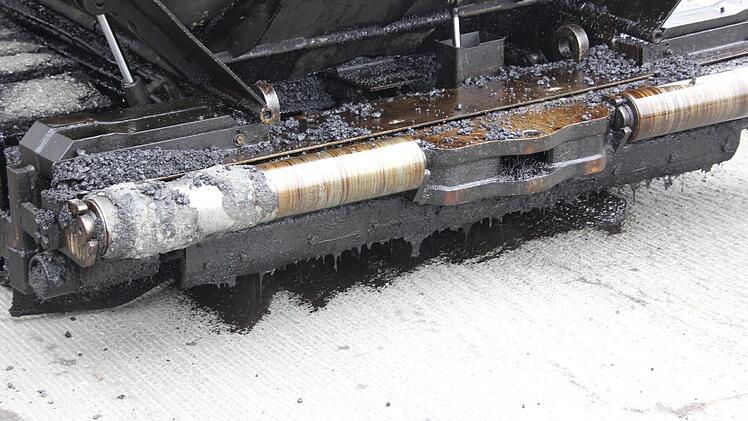 Aus der Asphaltierungsmaschine wird schwarzer Haftkleber C67 aufgesprüht. Foto: Friedwald Schedel