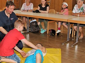 Stabile Seitenlage übten die Buben und Mädchen. Thomas Menz (links) zeigte ihnen, wie es funktioniert.  Fotos: Dieter Britz