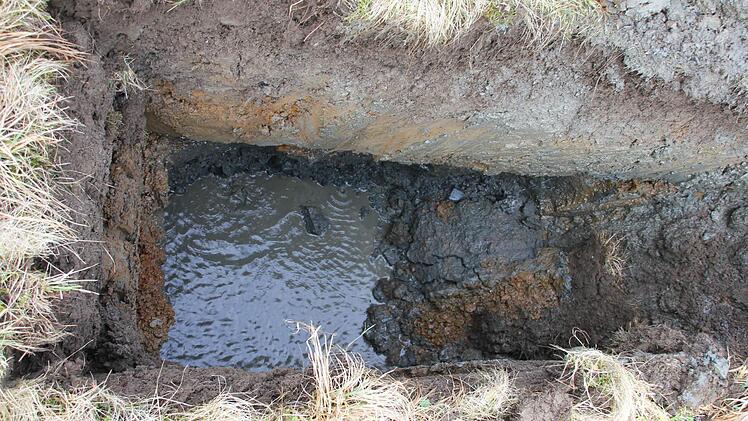 Blick in die drei Meter tiefe Schürfgrube mit den unterschiedlichen Bodenschichten. Schon nach wenigen Sekunden läuft Grundwasser in die Grube.