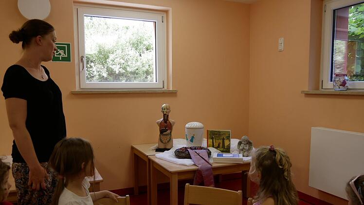 Mit Erzieherin Mareike betrachten die Kinder den Kofferinhalt. Darin ist alles Wissenswerte, was zum Thema Tod und Sterben gehört, kindgerecht.Manja von Nida
