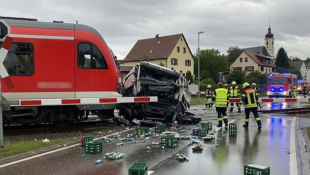 Zug fährt an Übergang im Kreis Aschaffenburg in Getränkelaster