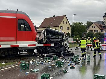 Zug fährt an Übergang im Kreis Aschaffenburg in Getränkelaster