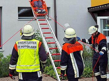 Eine "verletzte" und "eingeschlossene" Lehrerin der Grundschule Poppenlauer wird aus dem ersten Stock geborgen. Die Übung war der Abschluss der Brandschutzwoche in der Grundschule Foto: Dieter Britz