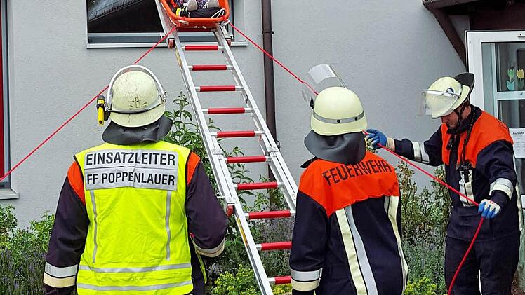 Eine "verletzte" und "eingeschlossene" Lehrerin der Grundschule Poppenlauer wird aus dem ersten Stock geborgen. Die Übung war der Abschluss der Brandschutzwoche in der Grundschule Foto: Dieter Britz