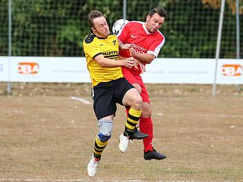 Der Küpser Spielertrainer Alexander Mertel (gelbes Trikot) und Andre Brendel gehen im Mittelfeld auf Körperkontakt. Foto: Heinrich Weiß