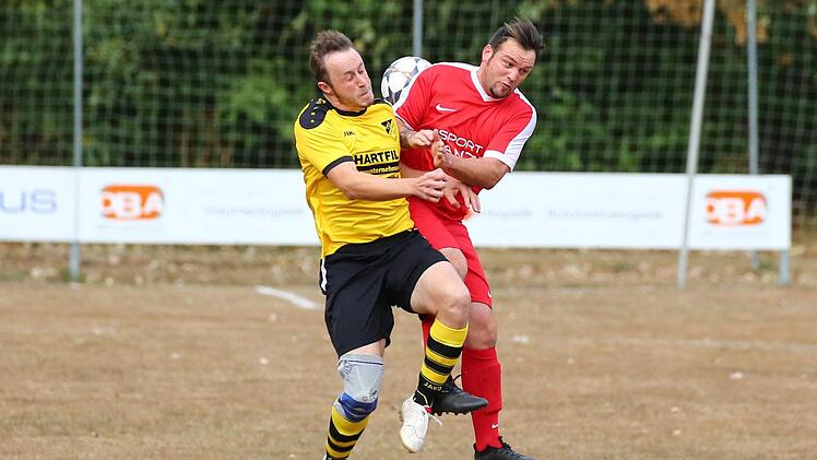 Der Küpser Spielertrainer Alexander Mertel (gelbes Trikot) und Andre Brendel gehen im Mittelfeld auf Körperkontakt. Foto: Heinrich Weiß