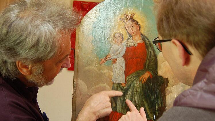 Restaurator Reinhold Müller und Pfarrer Thomas Eschenbacher begutachten das renovierte Bild. Foto: Barbara Oschmann