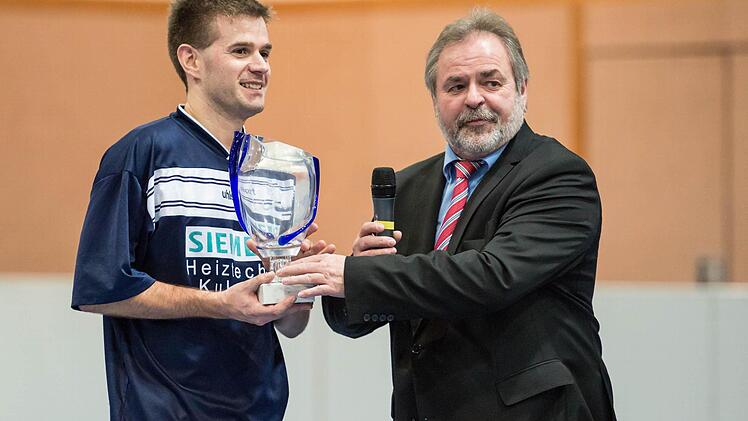 Marktleugasts Bürgermeister Norbert Volk überreicht dem Kapitän des siegreichen FC Marktleugast, Daniel Schramm, die Siegertrophäe.