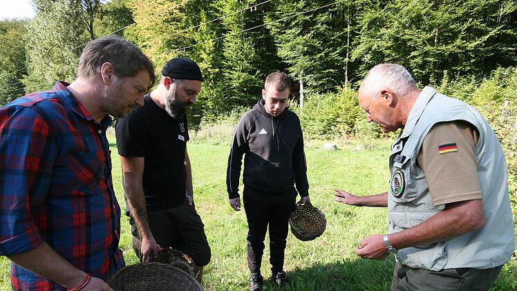 Dieter Beyfuß erklärt drei Teilnehmern, welche Pflanzen essbar sind. Foto: Marion Eckert