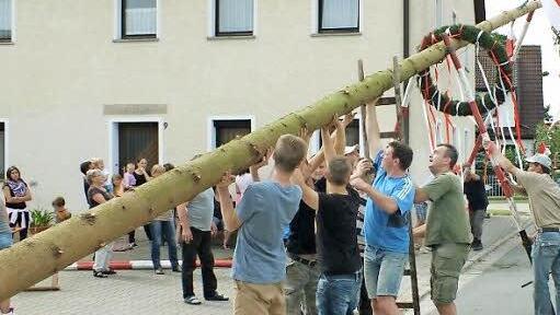 Die Hesselberger Ortsburschen stemmen die Fichte in die Höhe.