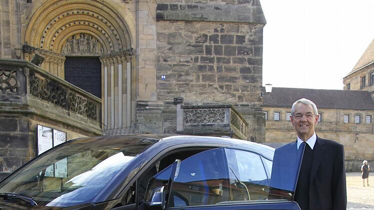 Erzbischof Ludwig Schick hat zwei Elektroautos in seinem Fuhrpark: Sein BMW wird mit Ökostrom geladen.  Foto: Erzbistum Bamberg