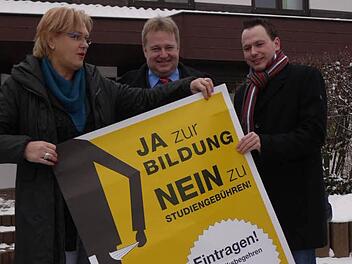 Irene Häusler, Axel Rogner und Patrick Prell hängen Plakate auf. Foto: Pauline Lindner