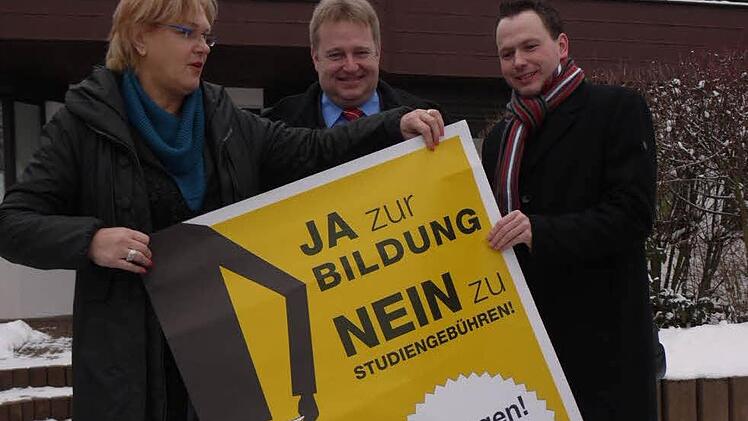 Irene Häusler, Axel Rogner und Patrick Prell hängen Plakate auf. Foto: Pauline Lindner