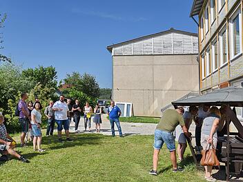 Bürgermeister Marco Friepes (weißes T-Shirt) erklärt die Sanierung der Schule; rechts am Pavillon können  sich die Räte anhand von Planunterlagen über die anstehenden Maßnahmen  informieren.      Foto: Karl Heinz Wirth