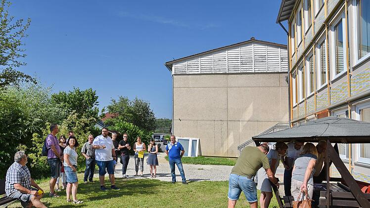 Bürgermeister Marco Friepes (weißes T-Shirt) erklärt die Sanierung der Schule; rechts am Pavillon können  sich die Räte anhand von Planunterlagen über die anstehenden Maßnahmen  informieren.      Foto: Karl Heinz Wirth