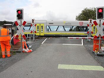 Am Bahnübergang Theisau herrscht derzeit noch manueller Betrieb. Die Arbeiter vor Ort erhalten einen Anruf vom Fahrdienstleiter, wann ein Zug Hochstadt oder Mainleus passiert, und schließen dann die Schranken. Fotos: Stephan Stöckel