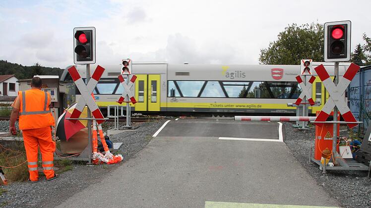 Am Bahnübergang Theisau herrscht derzeit noch manueller Betrieb. Die Arbeiter vor Ort erhalten einen Anruf vom Fahrdienstleiter, wann ein Zug Hochstadt oder Mainleus passiert, und schließen dann die Schranken. Fotos: Stephan Stöckel