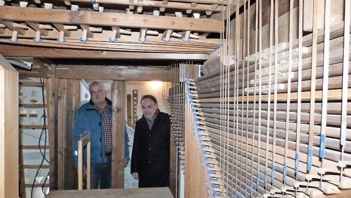 Karl-Heinz Krüger (links) und Pfarrer Peter Brünnhäuser blicken in das Innengehäuse der Wirsberger Kirchenorgel.