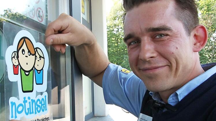 Hier klebt der Chef noch selbst. Lidl-Fililalleiter Sebastian Richter bringt den Notinsel-Aufkleber in Augenhöhe der Kinder an.  Fotos: Josef Hofbauer